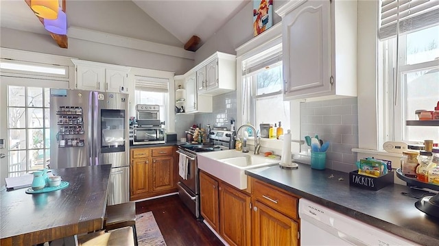 kitchen featuring lofted ceiling, appliances with stainless steel finishes, white cabinets, and decorative backsplash