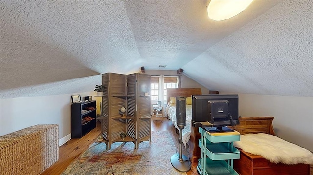 bonus room featuring hardwood / wood-style flooring, lofted ceiling, and a textured ceiling