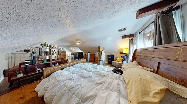 bedroom with vaulted ceiling, hardwood / wood-style floors, and a textured ceiling