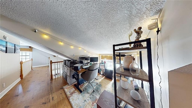 home office with hardwood / wood-style flooring, vaulted ceiling, and a textured ceiling