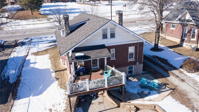 snow covered back of property featuring a wooden deck