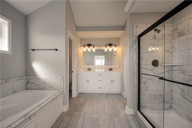 full bath featuring double vanity, a stall shower, baseboards, a sink, and a bath