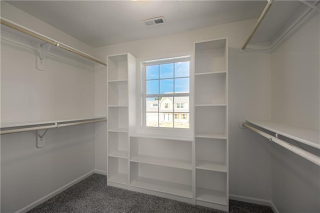 walk in closet featuring dark carpet and visible vents