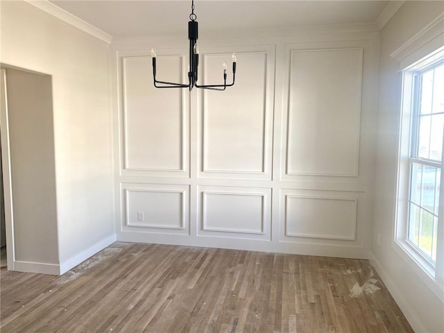 11821 N Bellaire Ave, Kansas City, MO 64156 - unfurnished dining area featuring a chandelier, wood finished floors, baseboards, plenty of natural light, and crown molding