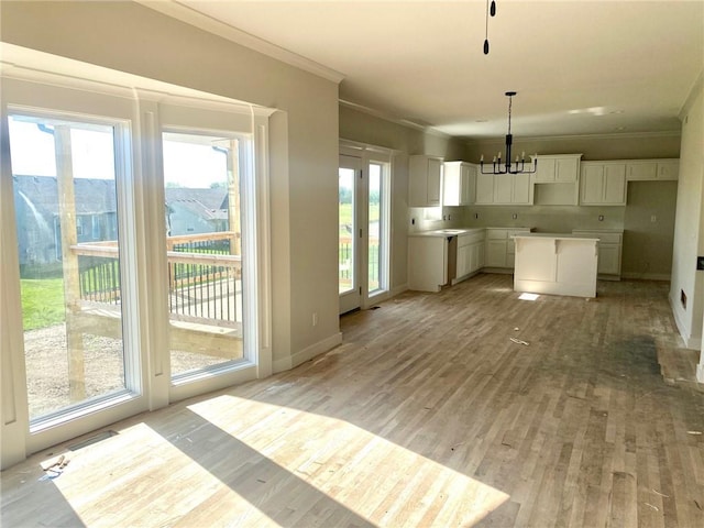 11821 N Bellaire Ave, Kansas City, MO 64156 - kitchen featuring a chandelier, ornamental molding, light wood-style flooring, white cabinets, and hanging light fixtures