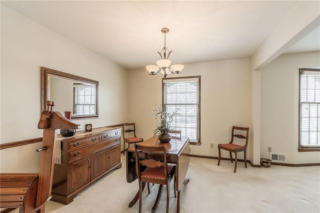 dining space with a wealth of natural light, light carpet, and a notable chandelier