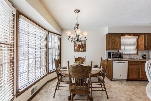 dining area featuring an inviting chandelier and sink