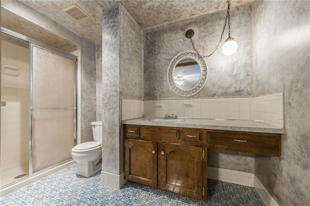 bathroom featuring vanity, tile patterned flooring, a shower with shower door, and toilet