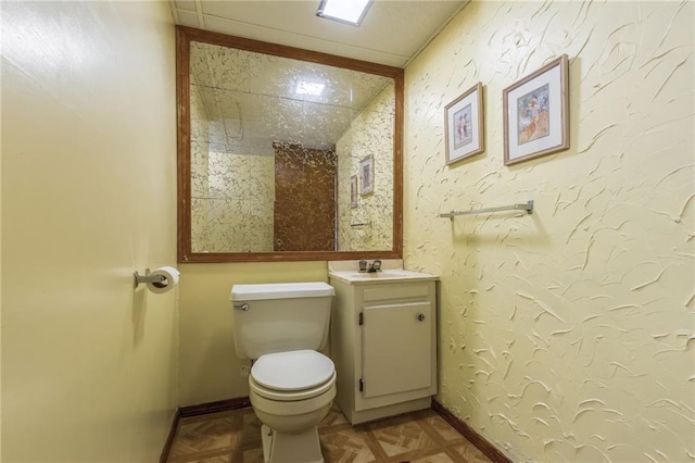 bathroom with vanity, parquet floors, and toilet