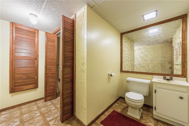 bathroom featuring vanity, parquet floors, a textured ceiling, and toilet