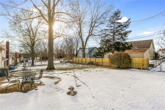 yard layered in snow with central AC unit