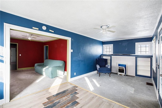 sitting room with ceiling fan, wood-type flooring, and a textured ceiling