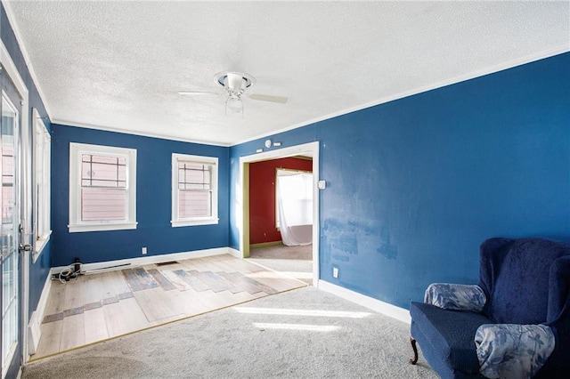 unfurnished room featuring ceiling fan, ornamental molding, light hardwood / wood-style floors, and a textured ceiling