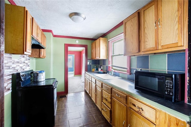 kitchen featuring sink, tasteful backsplash, a textured ceiling, dark tile patterned flooring, and black appliances