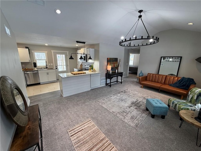 carpeted living room with sink, a chandelier, and vaulted ceiling