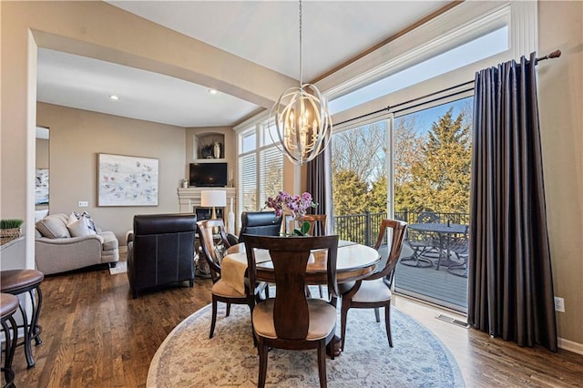 dining space featuring an inviting chandelier and dark hardwood / wood-style flooring