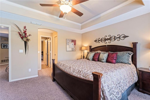 bedroom featuring a raised ceiling, ornamental molding, light carpet, and ceiling fan