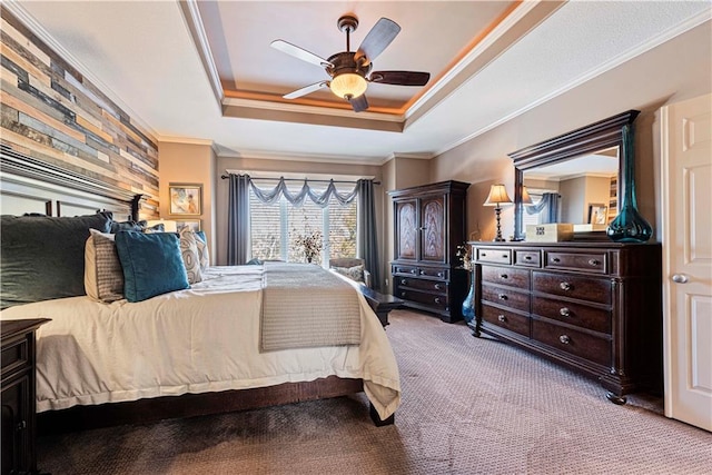 bedroom featuring ceiling fan, ornamental molding, a raised ceiling, and carpet floors