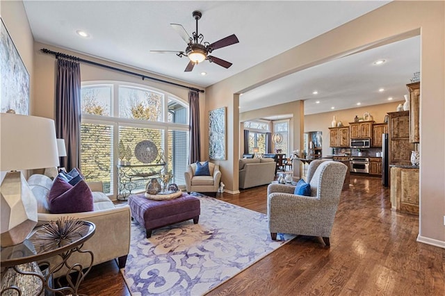 living room with ceiling fan and dark hardwood / wood-style floors