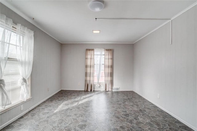 empty room featuring ornamental molding and plenty of natural light