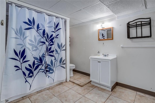 full bathroom with tile patterned flooring, vanity, shower / tub combo, toilet, and a drop ceiling