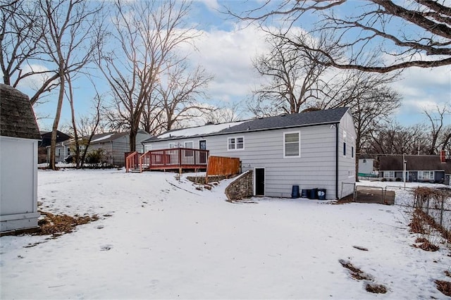 snow covered house with a deck