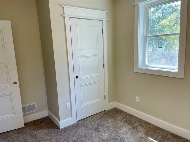 unfurnished bedroom with baseboards, carpet flooring, and visible vents