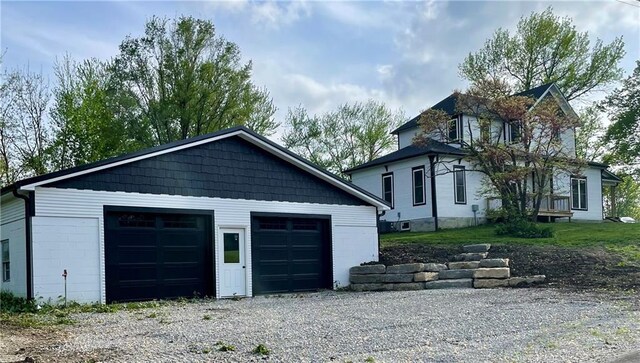 view of property exterior featuring a detached garage and an outbuilding