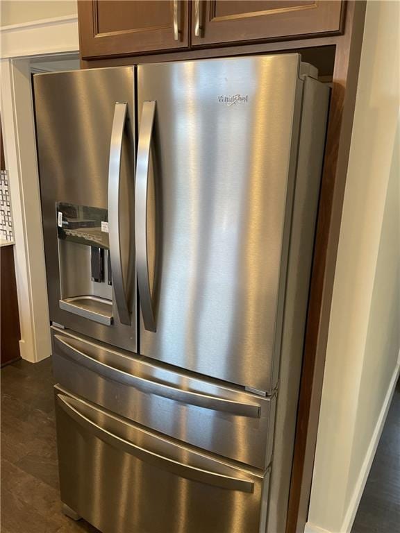 room details featuring stainless steel fridge with ice dispenser and baseboards