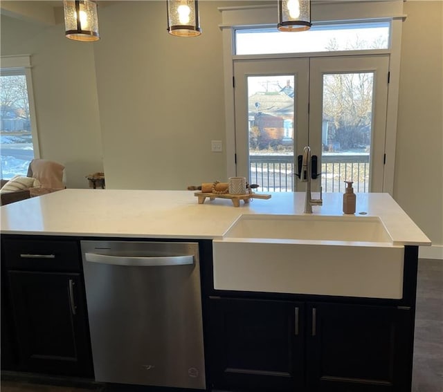 kitchen with dark cabinets, light countertops, a sink, and dishwasher