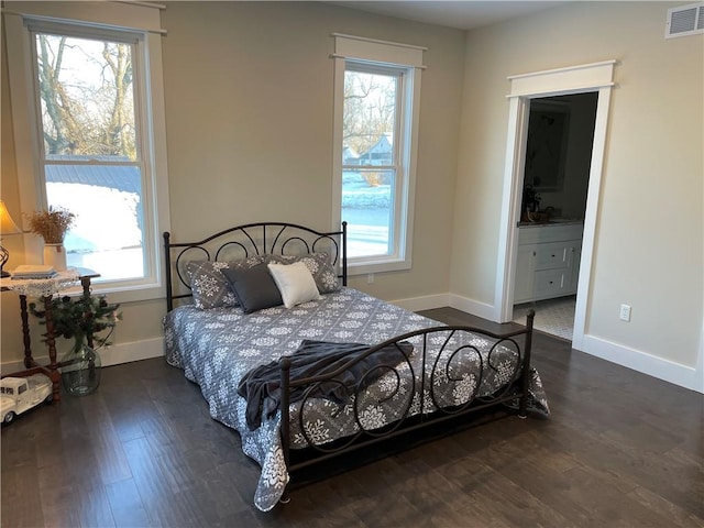 bedroom featuring visible vents, dark wood-style floors, and multiple windows