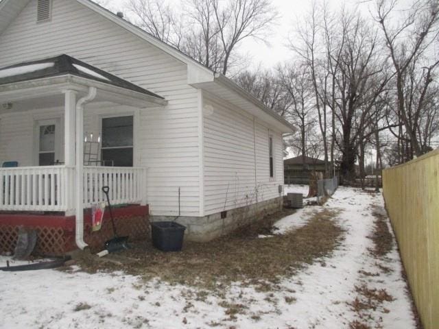 view of snowy exterior with covered porch