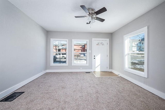 interior space featuring ceiling fan, a textured ceiling, and a healthy amount of sunlight