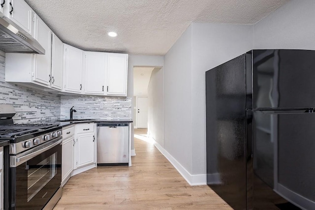 kitchen featuring stainless steel appliances, sink, light hardwood / wood-style floors, and white cabinets