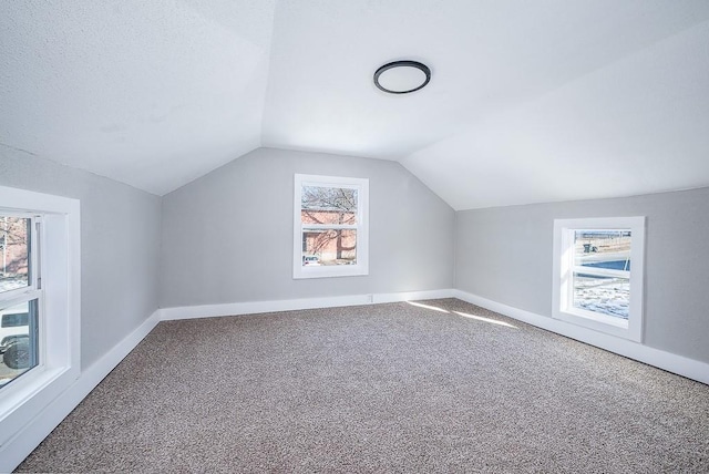 bonus room featuring vaulted ceiling and carpet