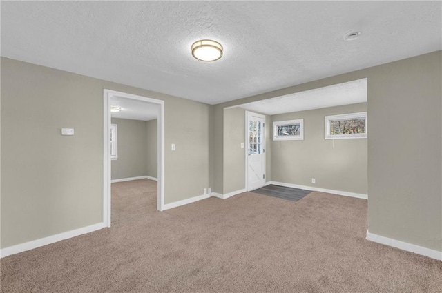 unfurnished room featuring light colored carpet and a textured ceiling