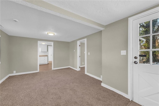 unfurnished room with carpet floors and a textured ceiling