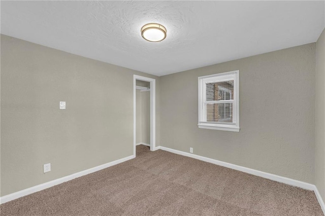 carpeted empty room with a textured ceiling