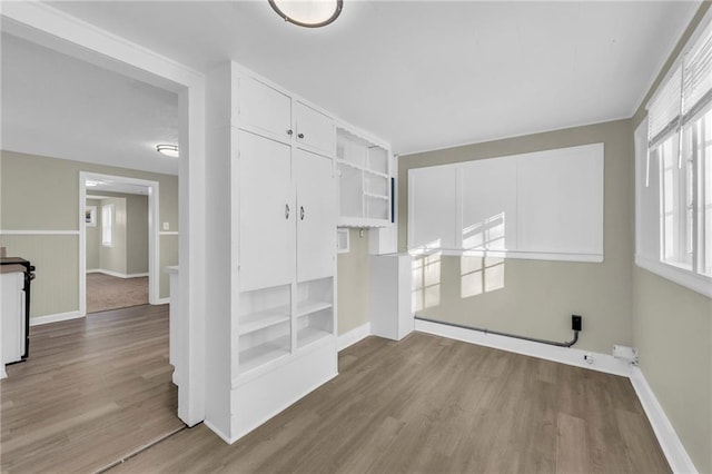 laundry area featuring built in shelves and light hardwood / wood-style flooring