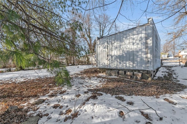 snow covered property with an outbuilding