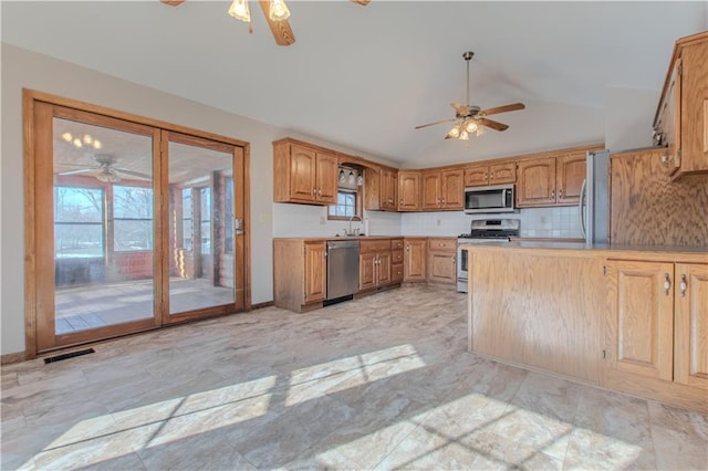 kitchen with lofted ceiling, tasteful backsplash, ceiling fan, and appliances with stainless steel finishes