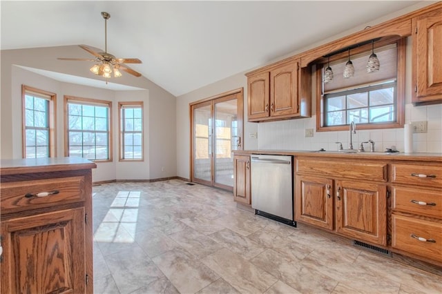 kitchen featuring lofted ceiling, sink, stainless steel dishwasher, and decorative backsplash