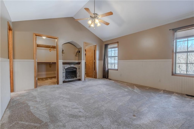 unfurnished living room with lofted ceiling, light carpet, and ceiling fan