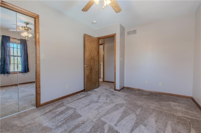 unfurnished bedroom with ceiling fan, a closet, and light carpet