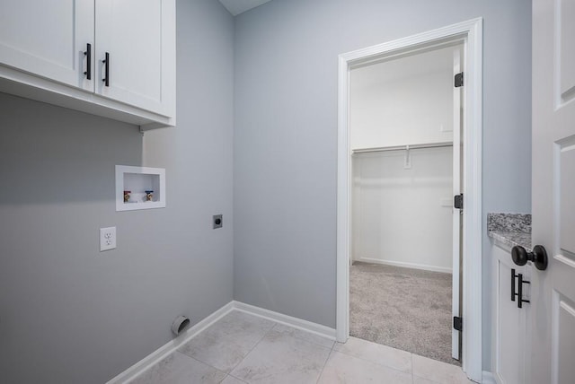 washroom with cabinet space, baseboards, light colored carpet, hookup for a washing machine, and electric dryer hookup