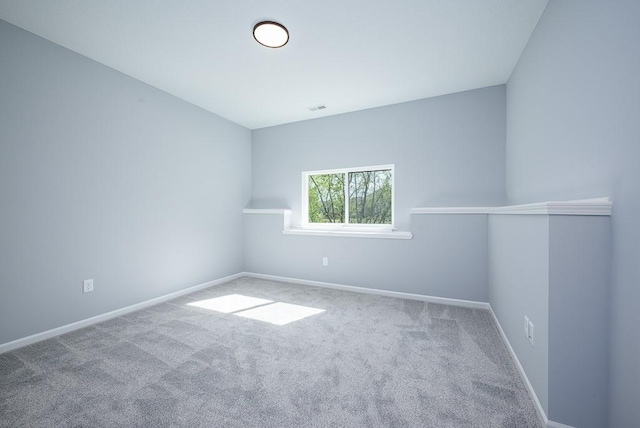 carpeted empty room featuring baseboards and visible vents