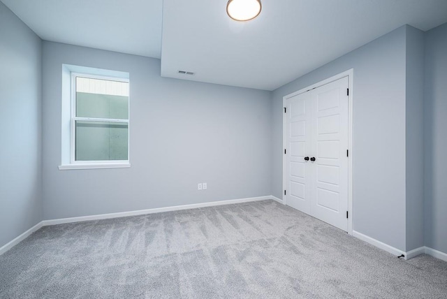 spare room with visible vents, light carpet, and baseboards