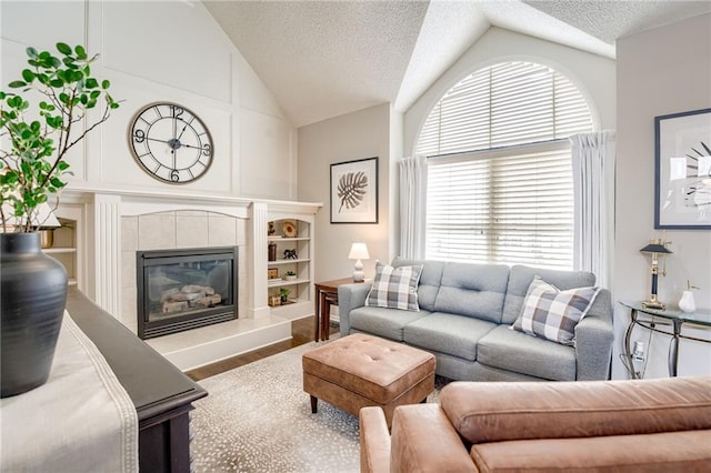 living room with hardwood / wood-style flooring, vaulted ceiling, and a textured ceiling