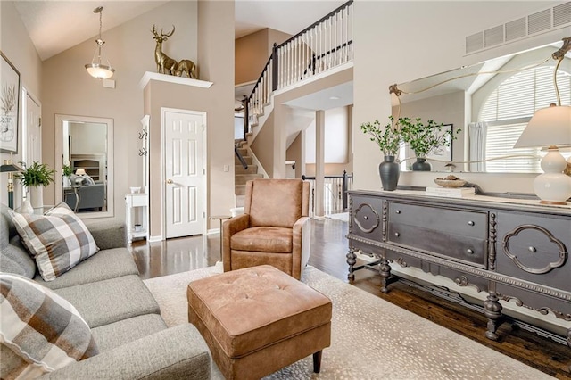 living room with dark hardwood / wood-style flooring and high vaulted ceiling