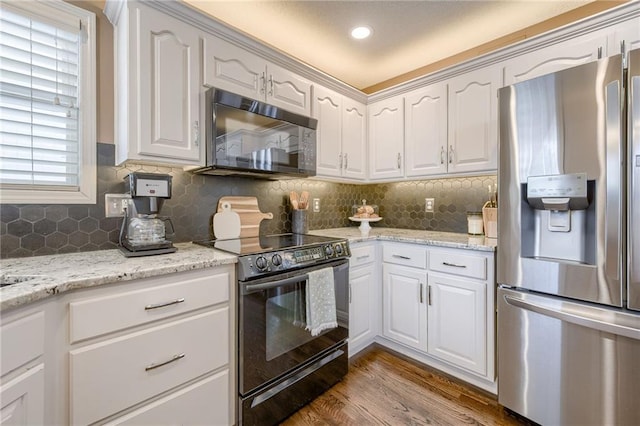 kitchen with backsplash, white cabinets, hardwood / wood-style floors, and black appliances